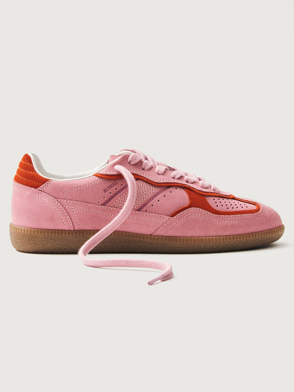 Pink clay colored suede low top lifestyle sneaker with red detailing. 
