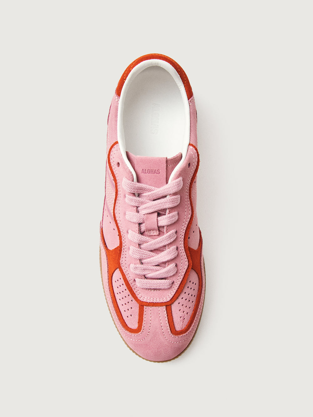 Pink clay colored suede low top lifestyle sneaker with red detailing. 