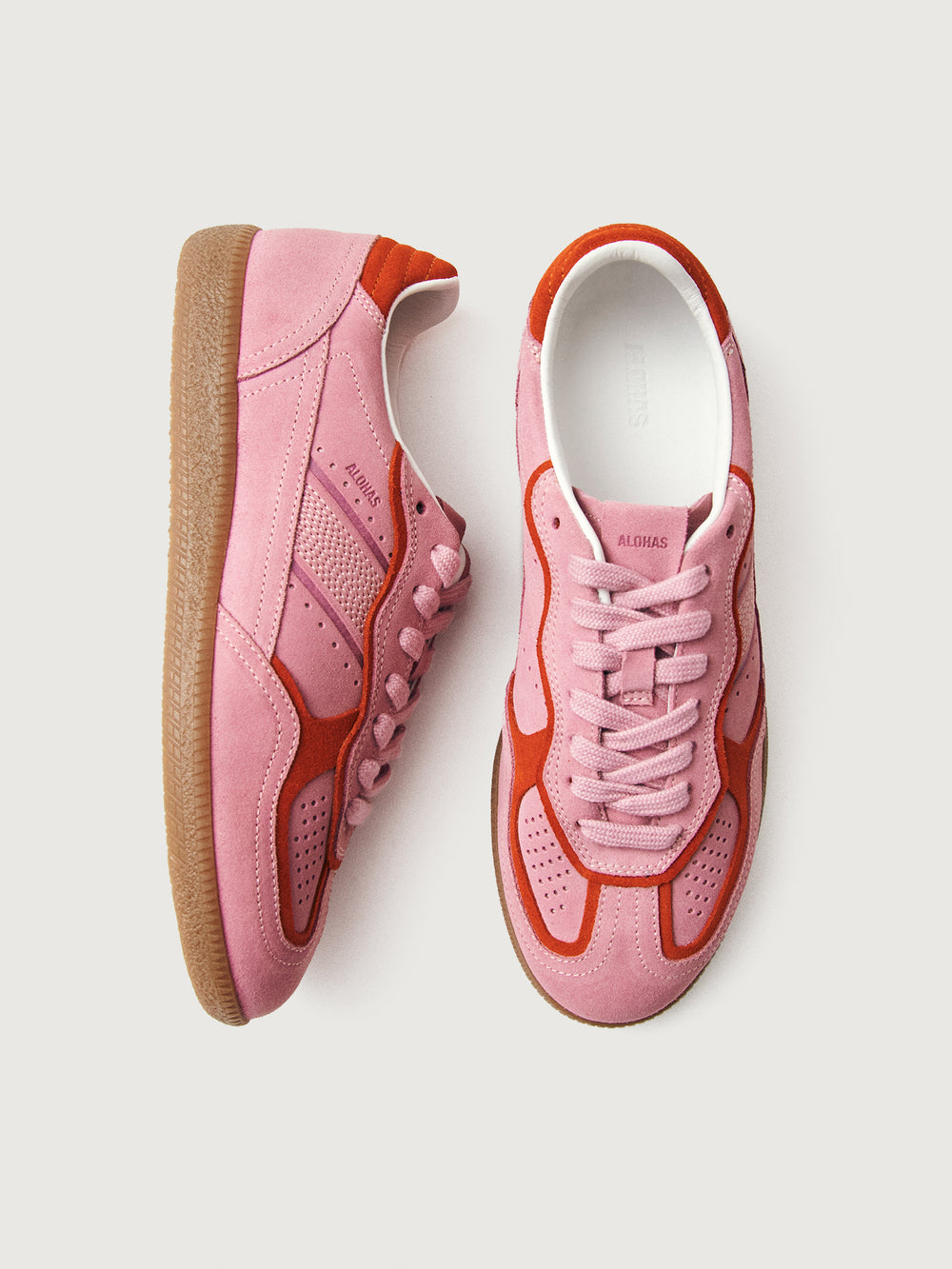 Pink clay colored suede low top lifestyle sneaker with red detailing. 