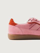 Pink clay colored suede low top lifestyle sneaker with red detailing. 