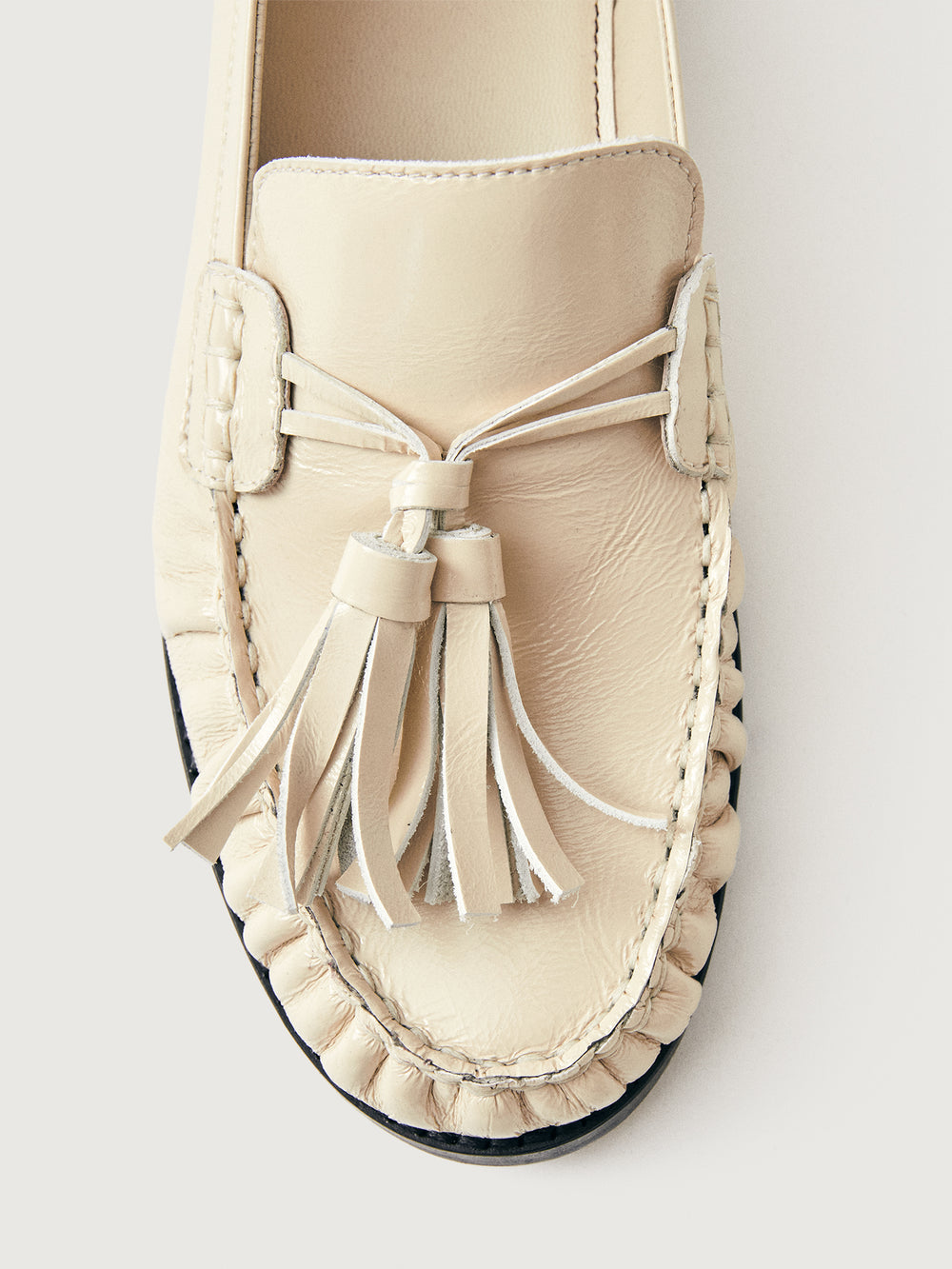 Beige loafer with tassel and black sole. 