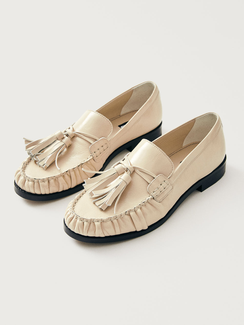Beige loafer with tassel and black sole. 