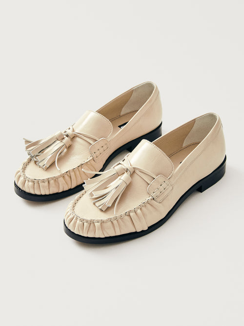 Beige loafer with tassel and black sole. 