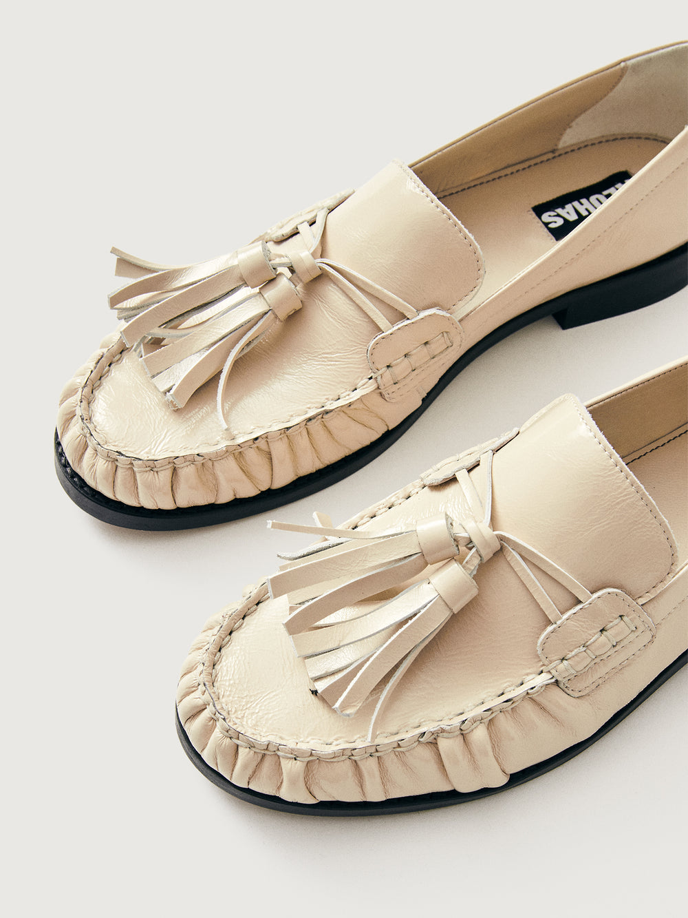 Beige loafer with tassel and black sole. 