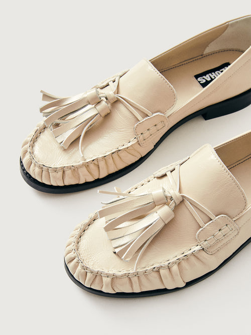 Beige loafer with tassel and black sole. 