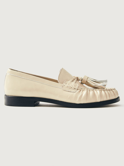 Beige loafer with tassel and black sole. 