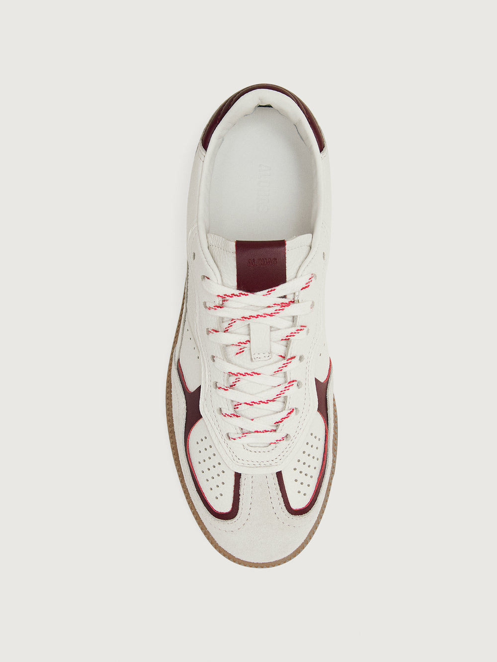 White sneaker with maroon accents.