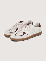 White sneaker with maroon accents.