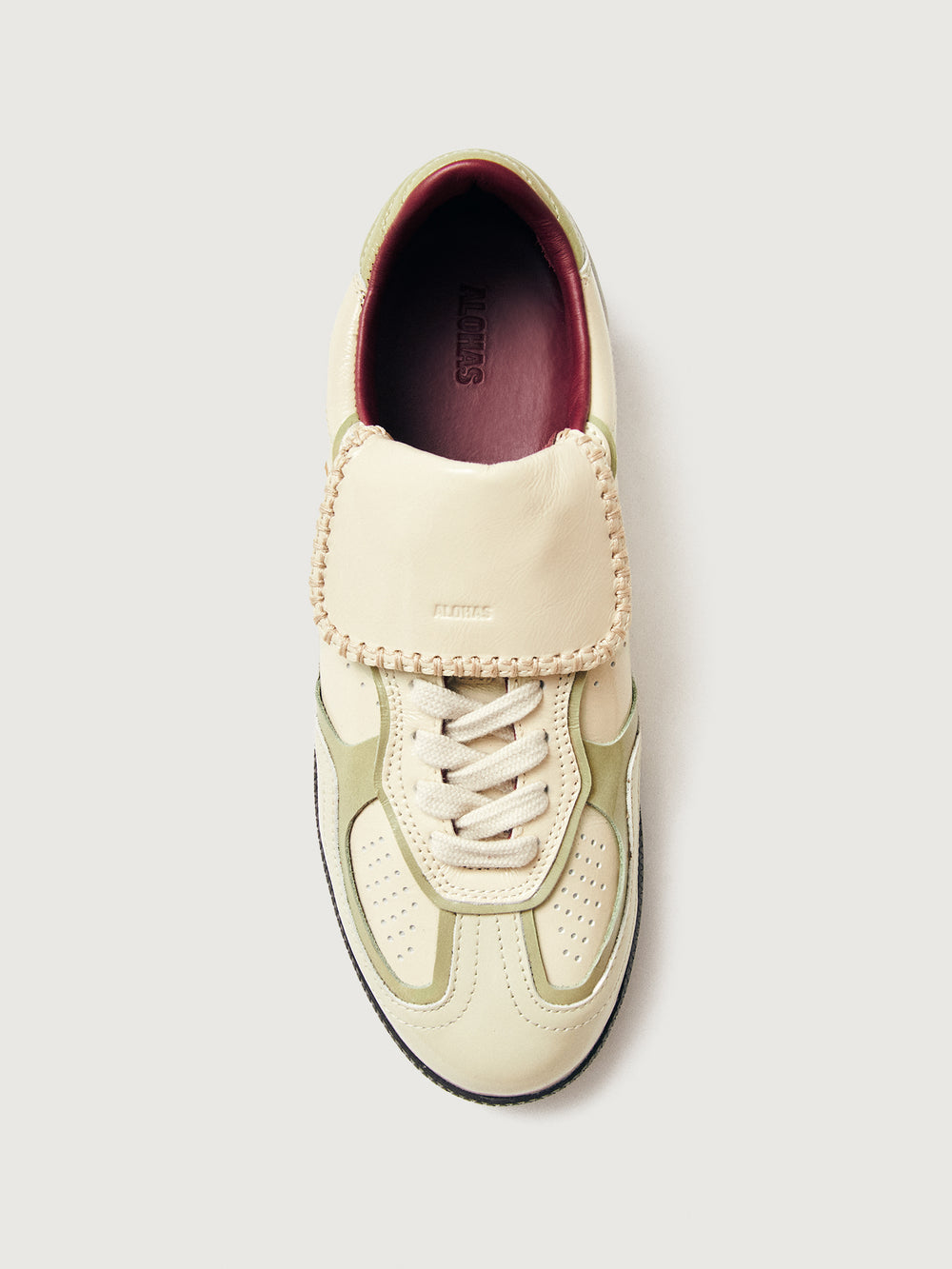 Creme colored low top lifestyle sneaker with black sole & gold/creme heel detailing. 