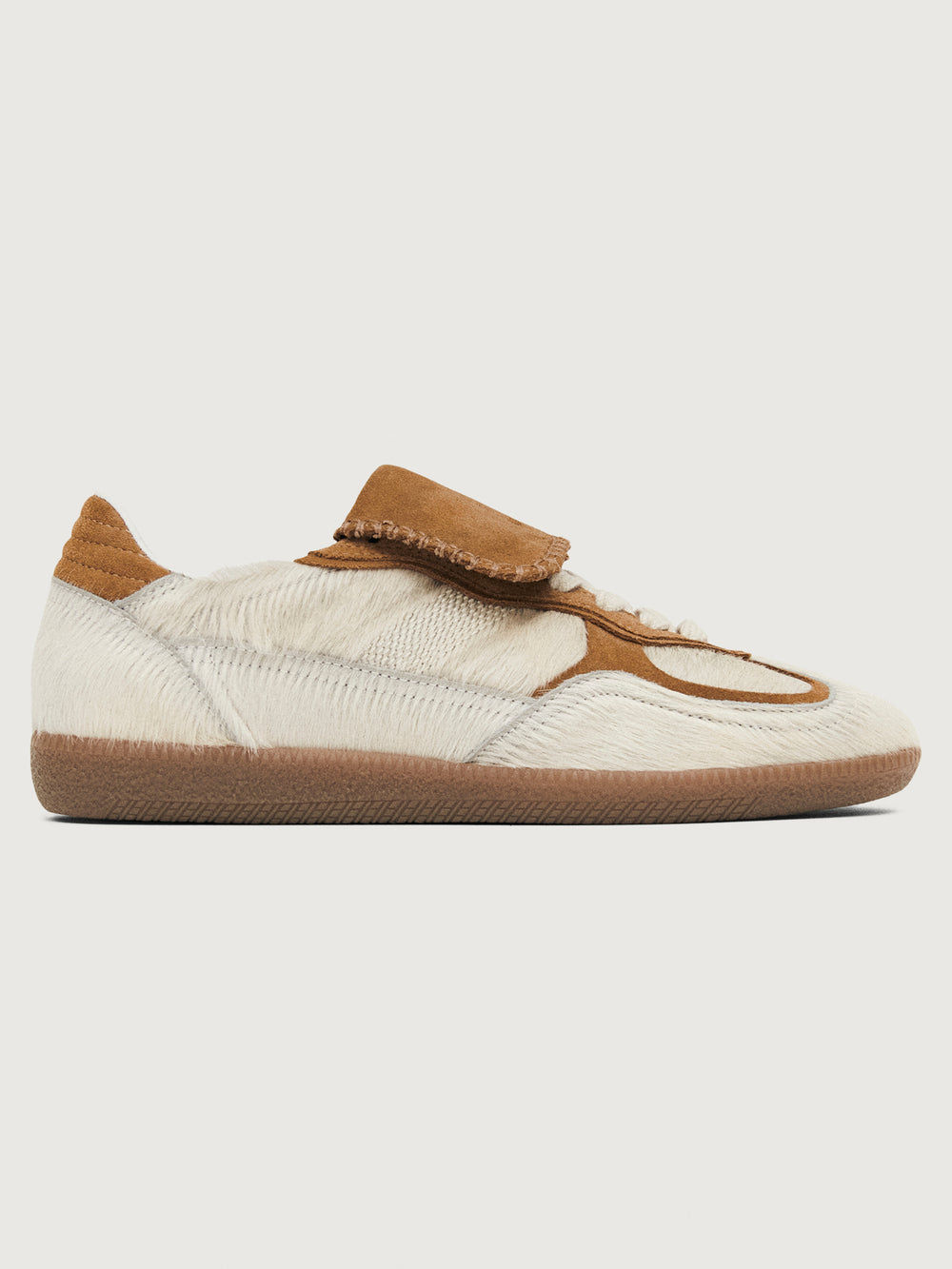 Neutral cowhair low top sneaker with chestnut tongue, sole, and heel. 