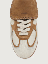 Neutral cowhair low top sneaker with chestnut tongue, sole, and heel. 