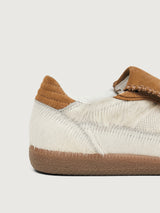 Neutral cowhair low top sneaker with chestnut tongue, sole, and heel. 