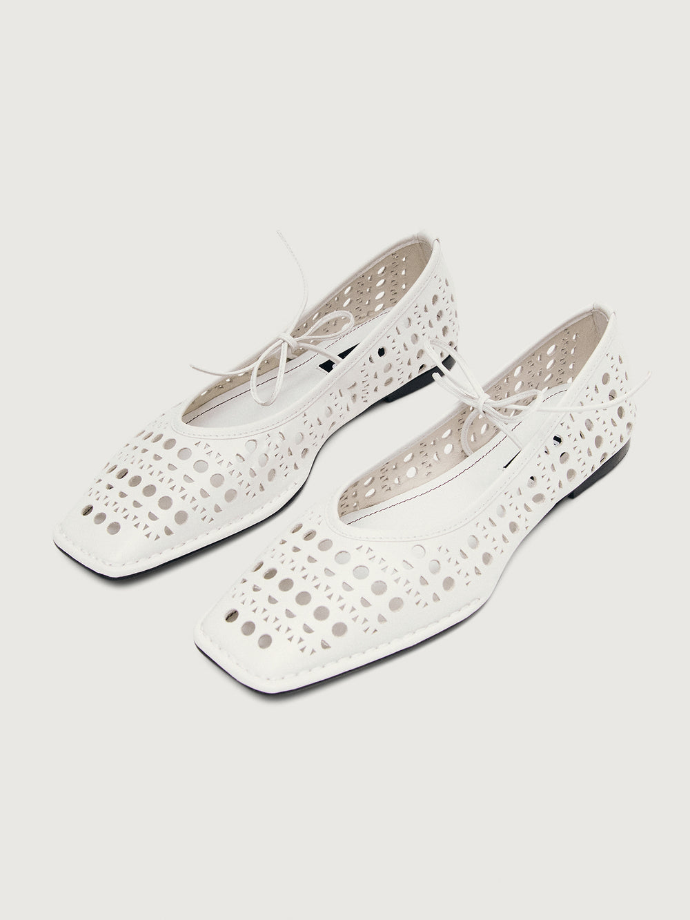 White flat shoe with cut-out design.