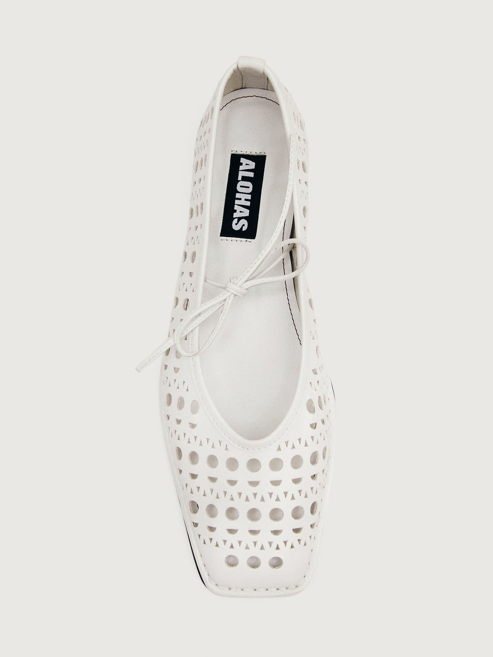 White flat shoe with cut-out design.