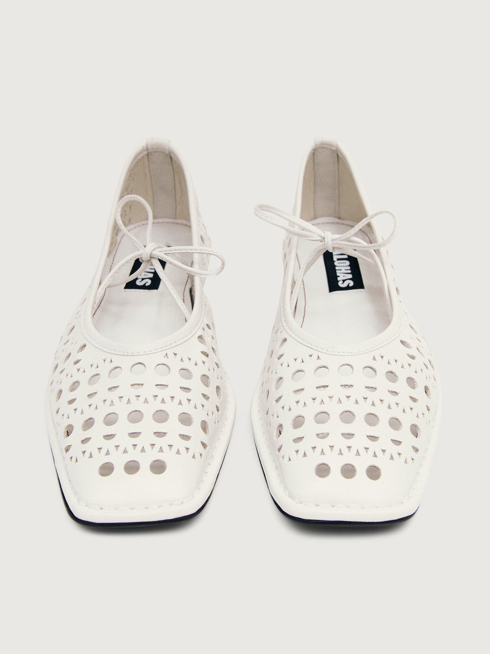 White flat shoe with cut-out design.