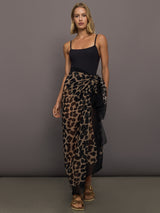 Model wears leopard print skirt with a long, flowy silhouette and a tie closure at the waist.

