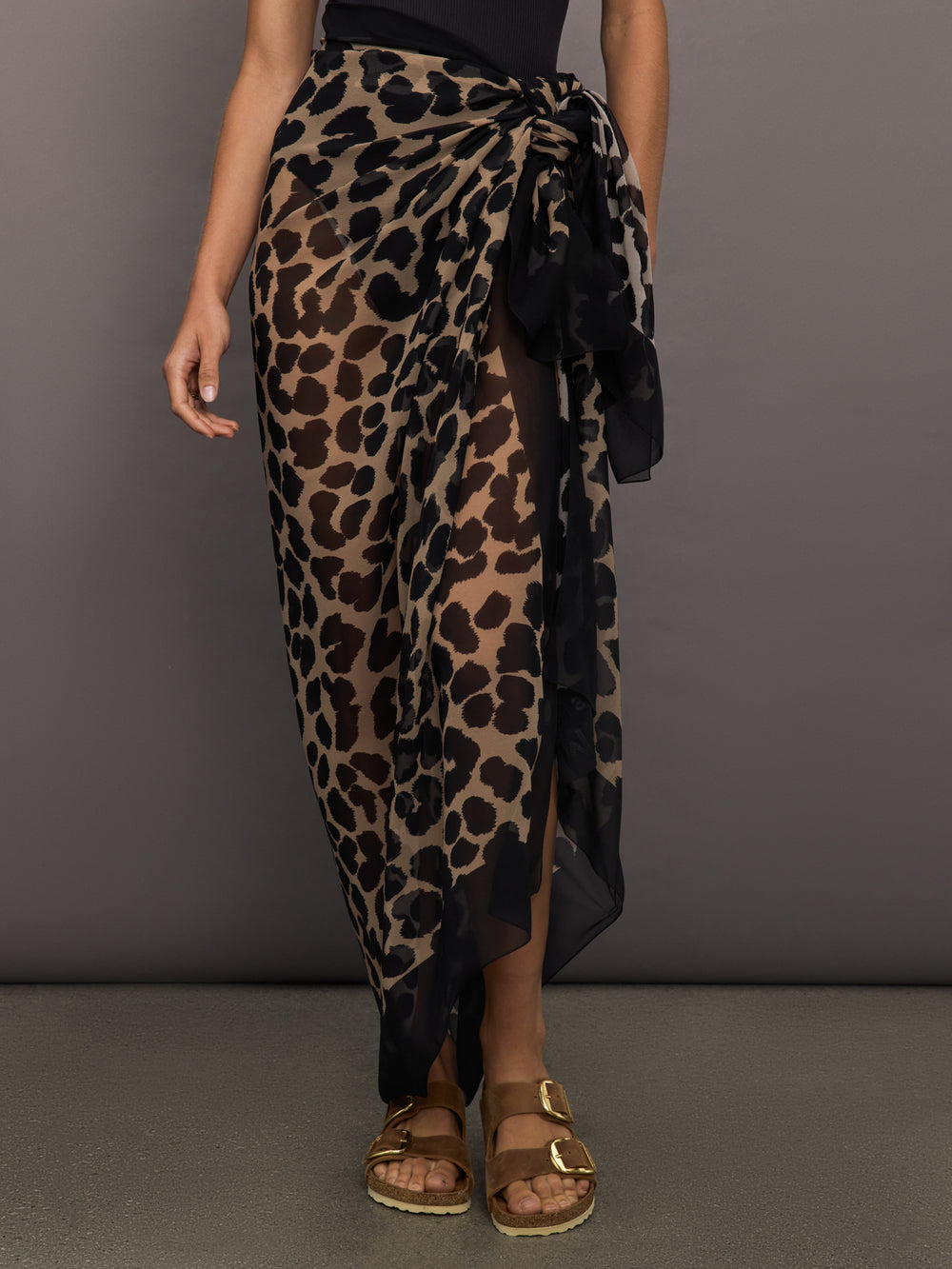 Model wears leopard print skirt with a long, flowy silhouette and a tie closure at the waist.




