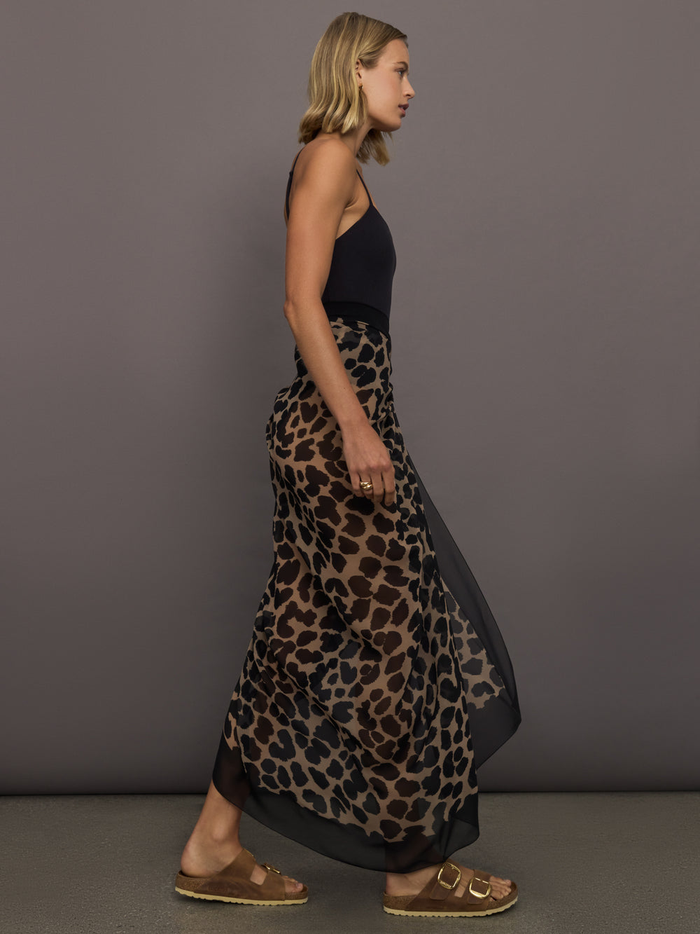 Model wears leopard print skirt with a long, flowy silhouette and a tie closure at the waist.
