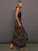 Model wears leopard print skirt with a long, flowy silhouette and a tie closure at the waist.

