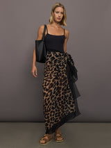 Model wears leopard print skirt with a long, flowy silhouette and a tie closure at the waist.
