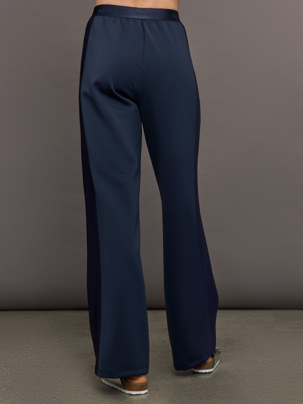 Model wears navy wide leg pants with an elastic waistband. 