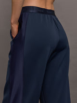 Model wears navy wide leg pants with an elastic waistband. 