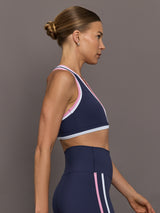 Side view of Ida Top in navy with contrast pink and white trim, showing racerback fit.
