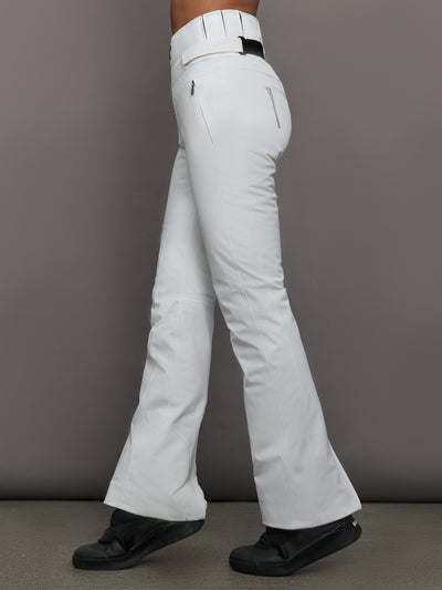 White snow pants worn by a person on a gray background