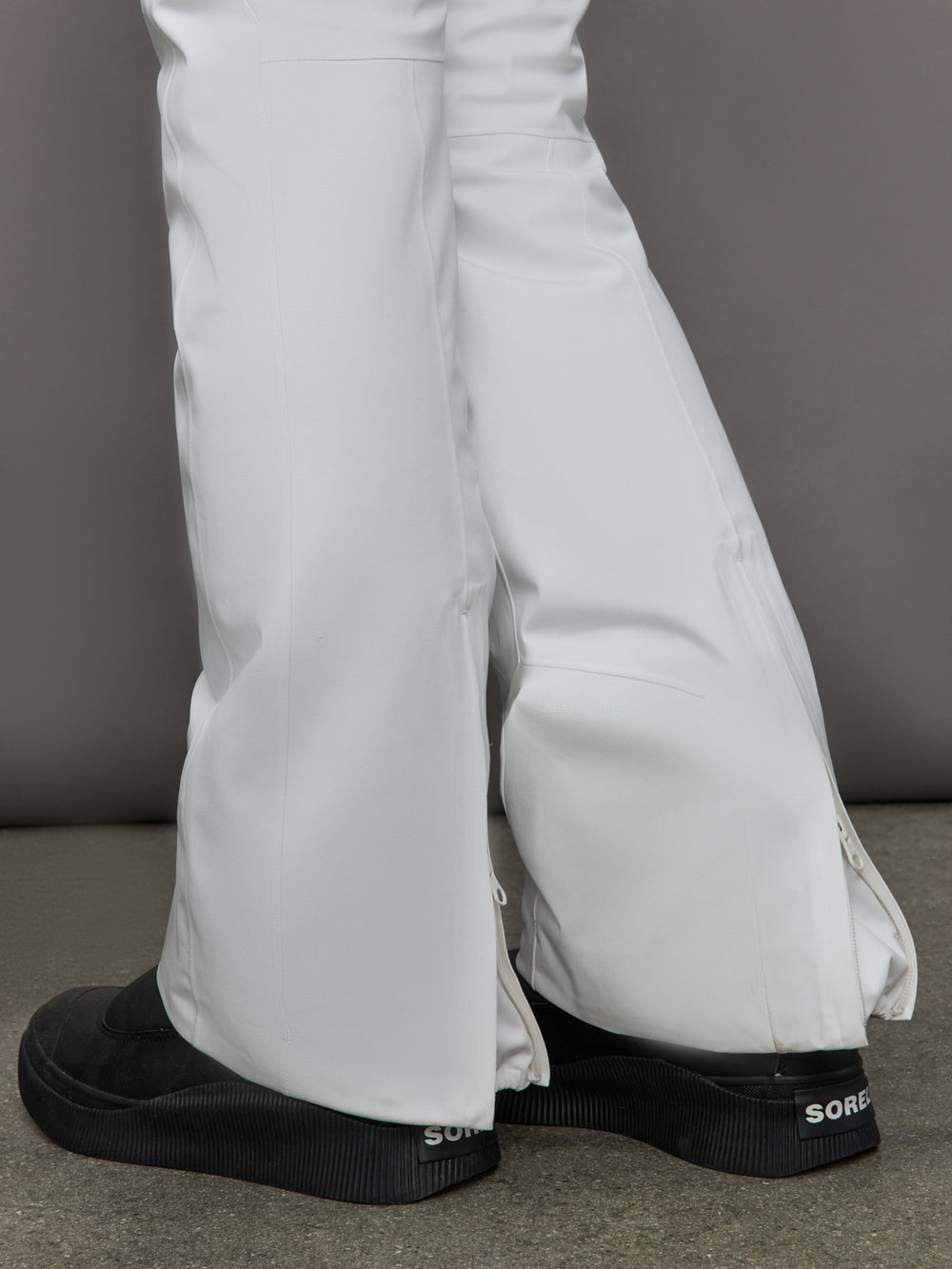White pants with black shoes on a neutral background