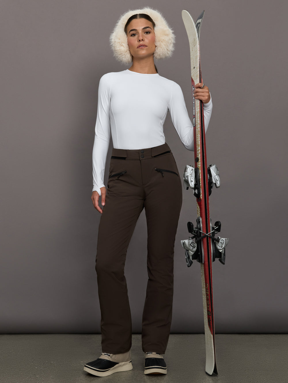 Person holding skis against a gray background
