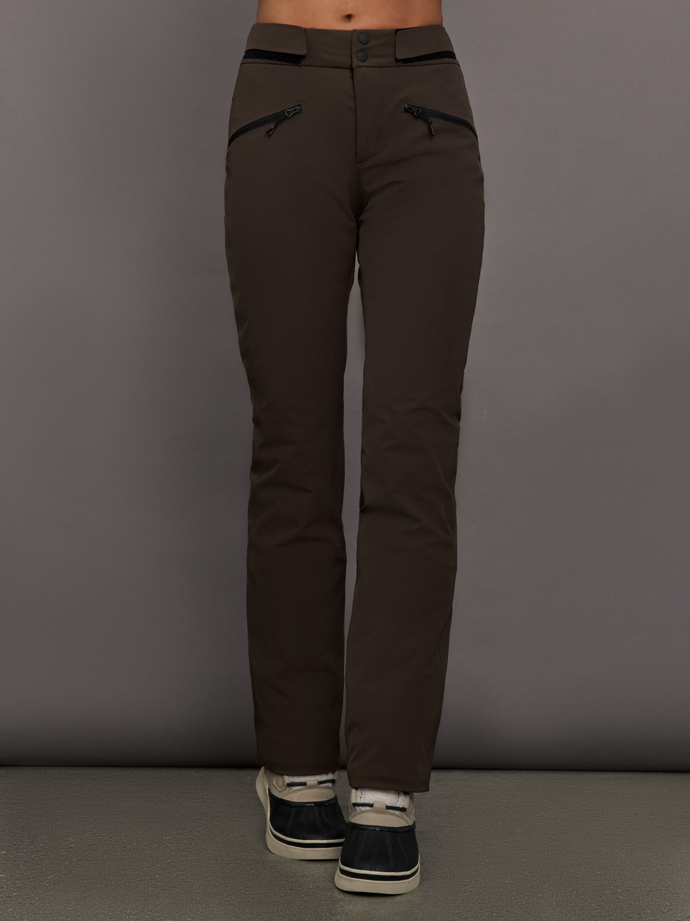 Brown pants worn by a person on a gray background