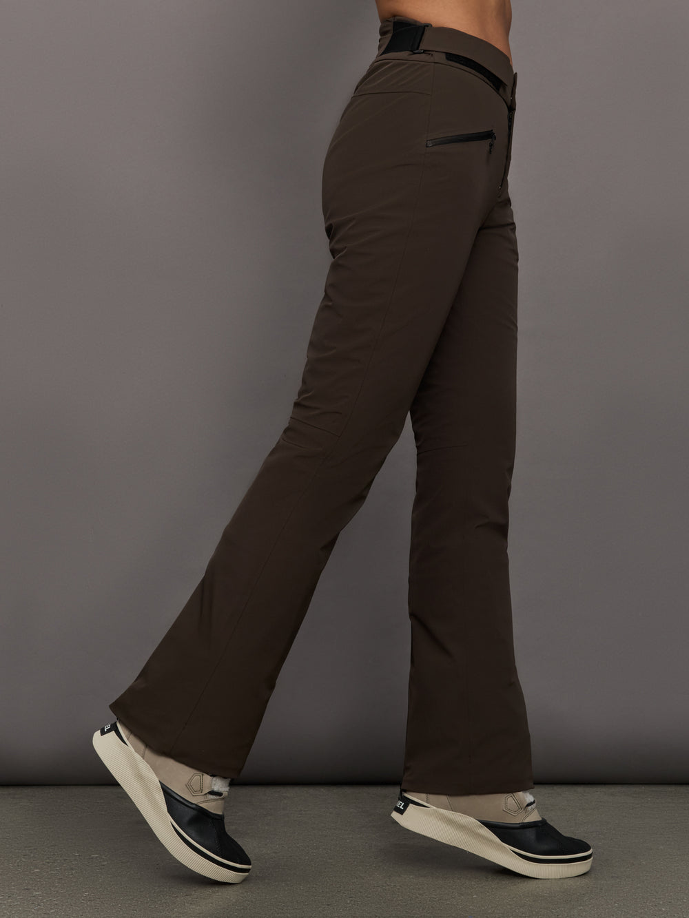 Brown pants worn by a person against a gray background