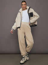 Full body view of model styled in ILMI Sweatpants Dune with shearling jacket and boots.