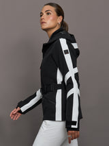 Woman wearing a black and white jacket with a gray background