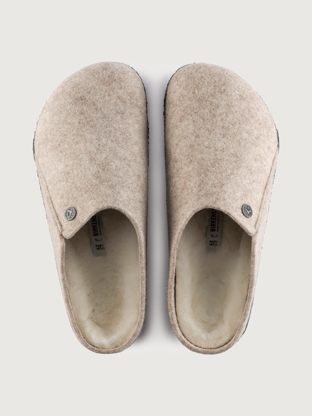 Pair of beige slippers on a white background