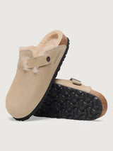 Beige suede clog shoe with a buckle on a light gray background
