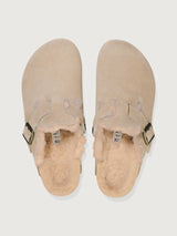 Beige suede clog shoe with a buckle on a light gray background