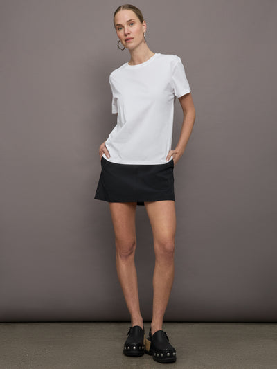 Model wears a basic white tee shirt with ringer neck and the word "Bandier" across the sleeve. 