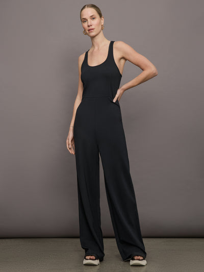 Model wears a black wide leg jumpsuit. 