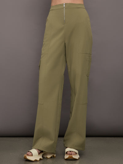 Model wears a pair of olive/khaki colored mid-rise wide leg cargo pants with cargo pockets on side, silver zipper in front. 