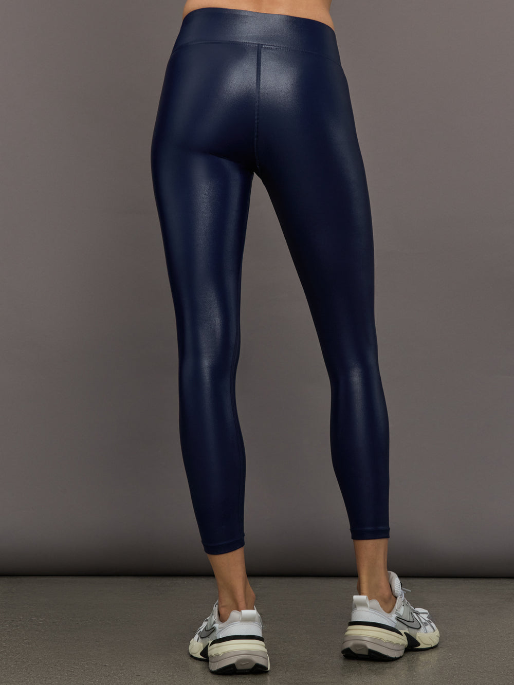 Model wears liquid takara shine leggings in regular rise with a thick waistband in navy.