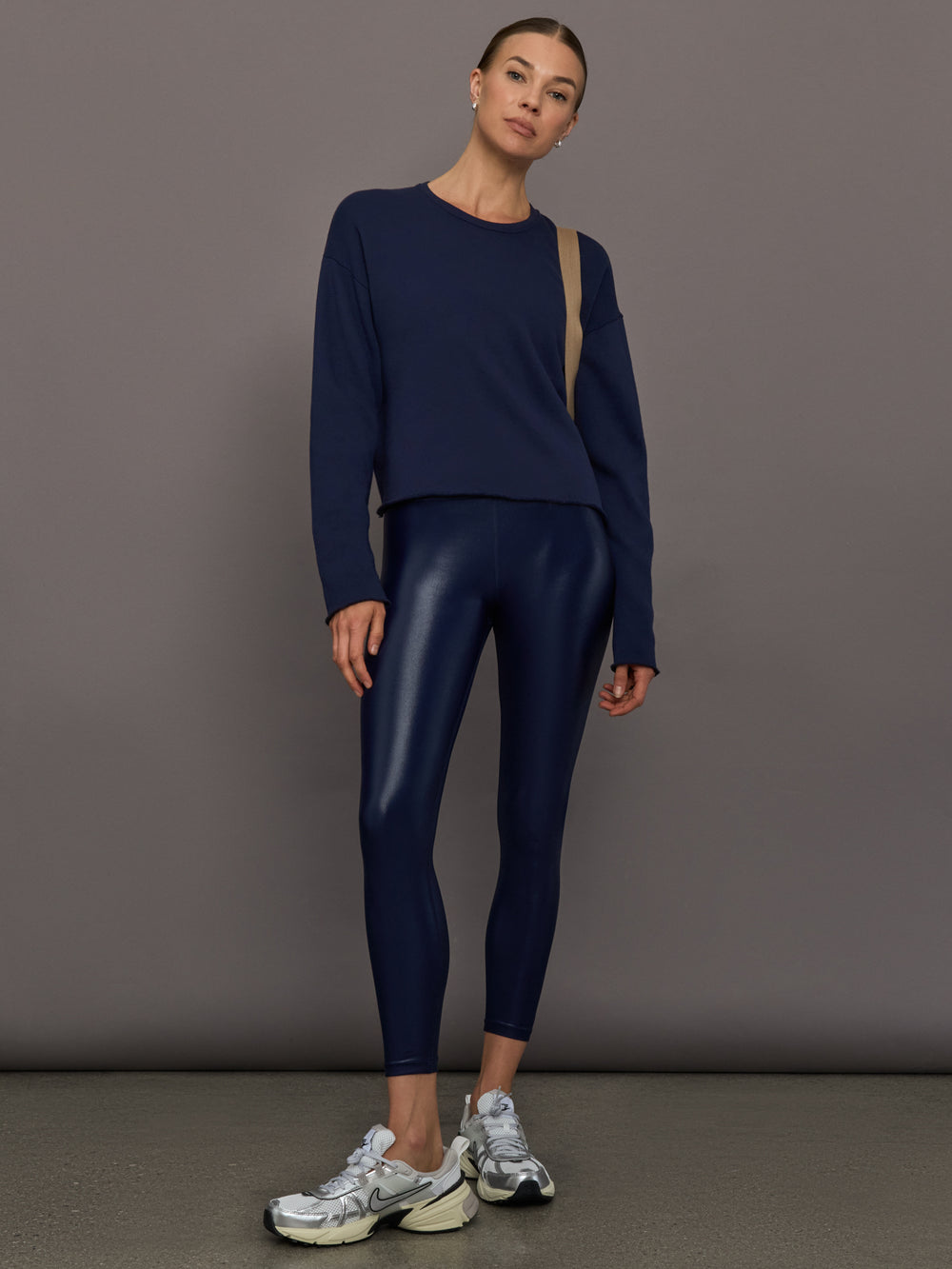 Model wears liquid takara shine leggings in regular rise with a thick waistband in navy.