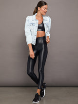 Model wears a high waisted pair of liquidy shine black leggings that hit at model's mid to low calf.