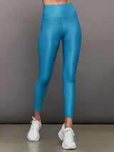 Model wears high rise, liquidy fabrication with crocodile texture, bright blue leggings. 