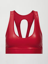 Model wears a bright red shiny, liquidlike sports bra with a v neck. 