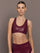 Model wearing Action Bra 2.0 in Takara Shine in Fig, paired with matching high-rise leggings, front view.