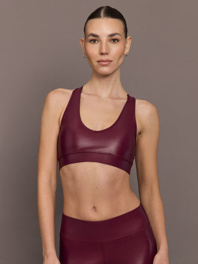 Model wearing Action Bra 2.0 in Takara Shine in Fig, paired with matching high-rise leggings, front view.