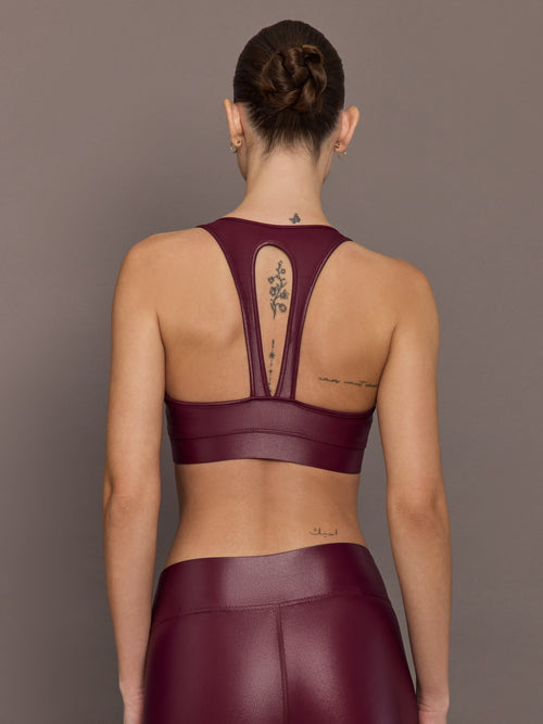Back view of Action Bra 2.0 in Takara Shine in Fig with racerback straps and cutout detail, paired with matching leggings.