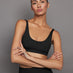 Model wearing ribbed scoop neck sports bra in black, front view.