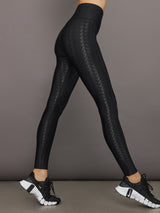 Model wears a pair of high waisted black houndstooth print leggings. 